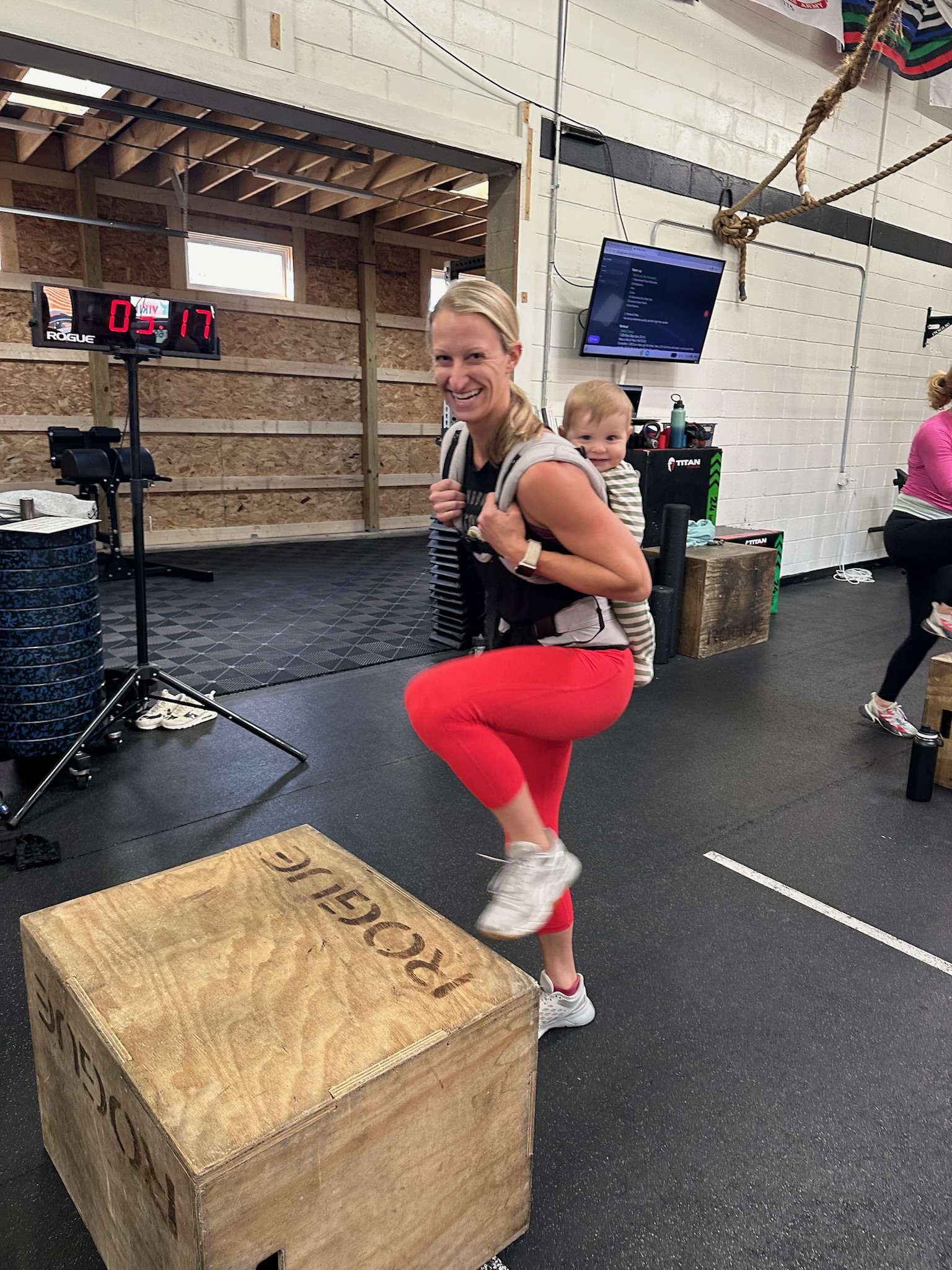 Coach helping a member with a box jump