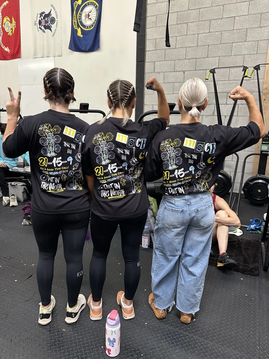 Moonshot CrossFit members in matching event shirts celebrating together at the gym