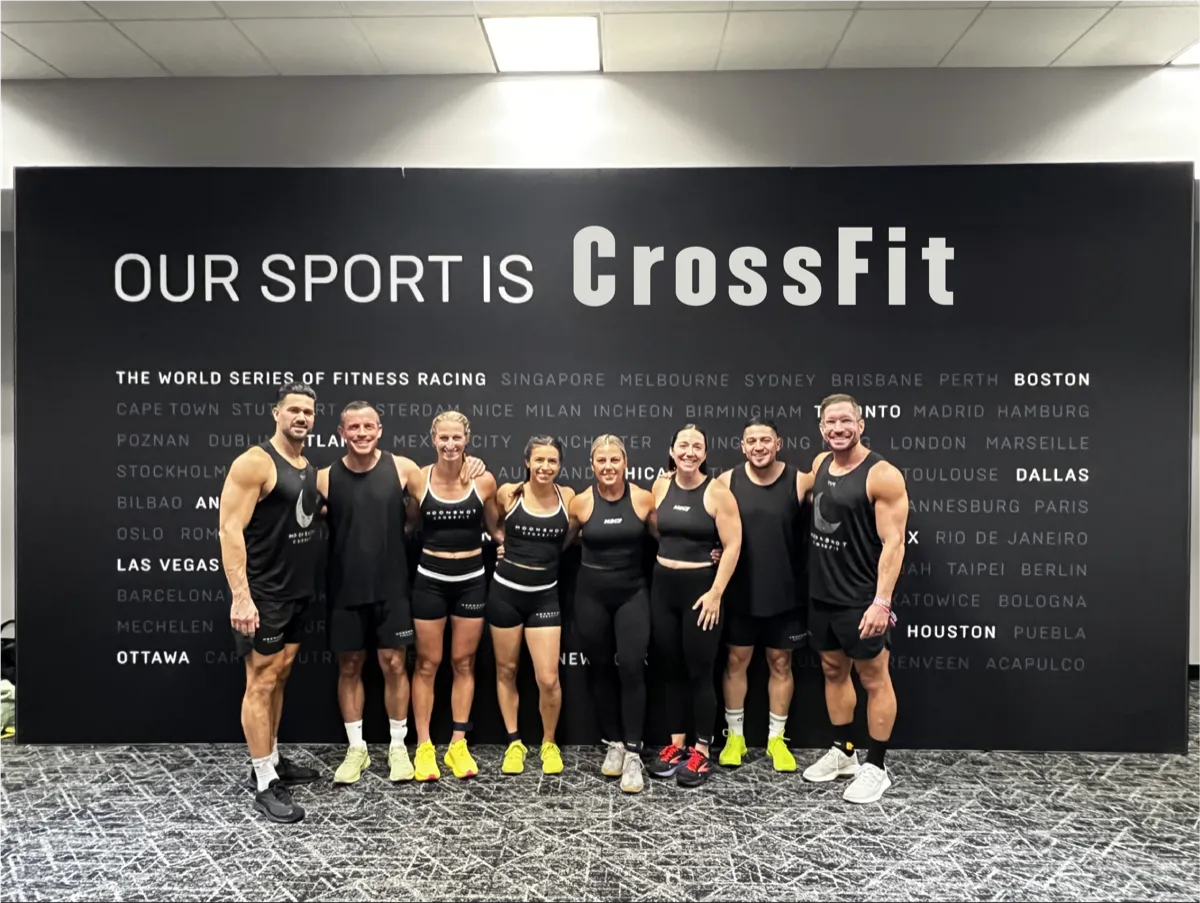 The Moonshot CrossFit competition team posing in front of the Our Sport Is CrossFit wall
