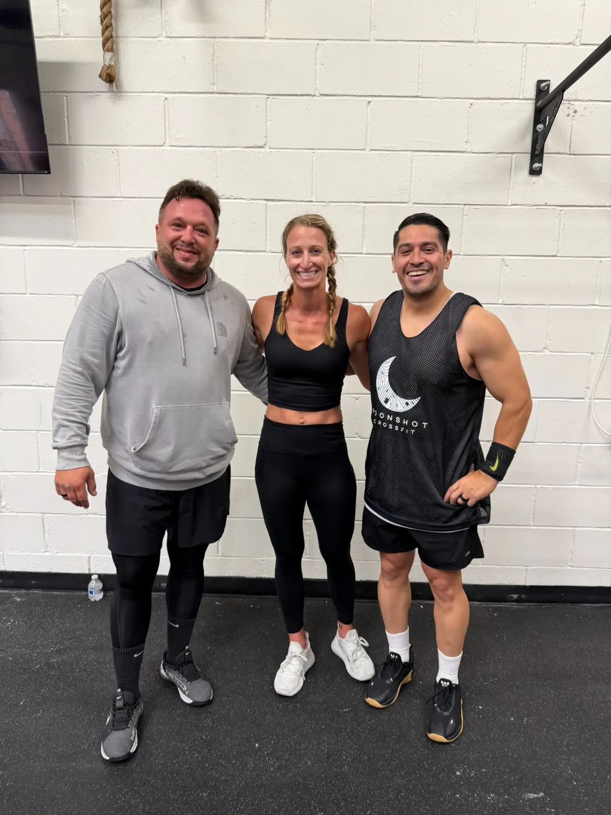 Three Moonshot CrossFit members posing together in the gym after a training session