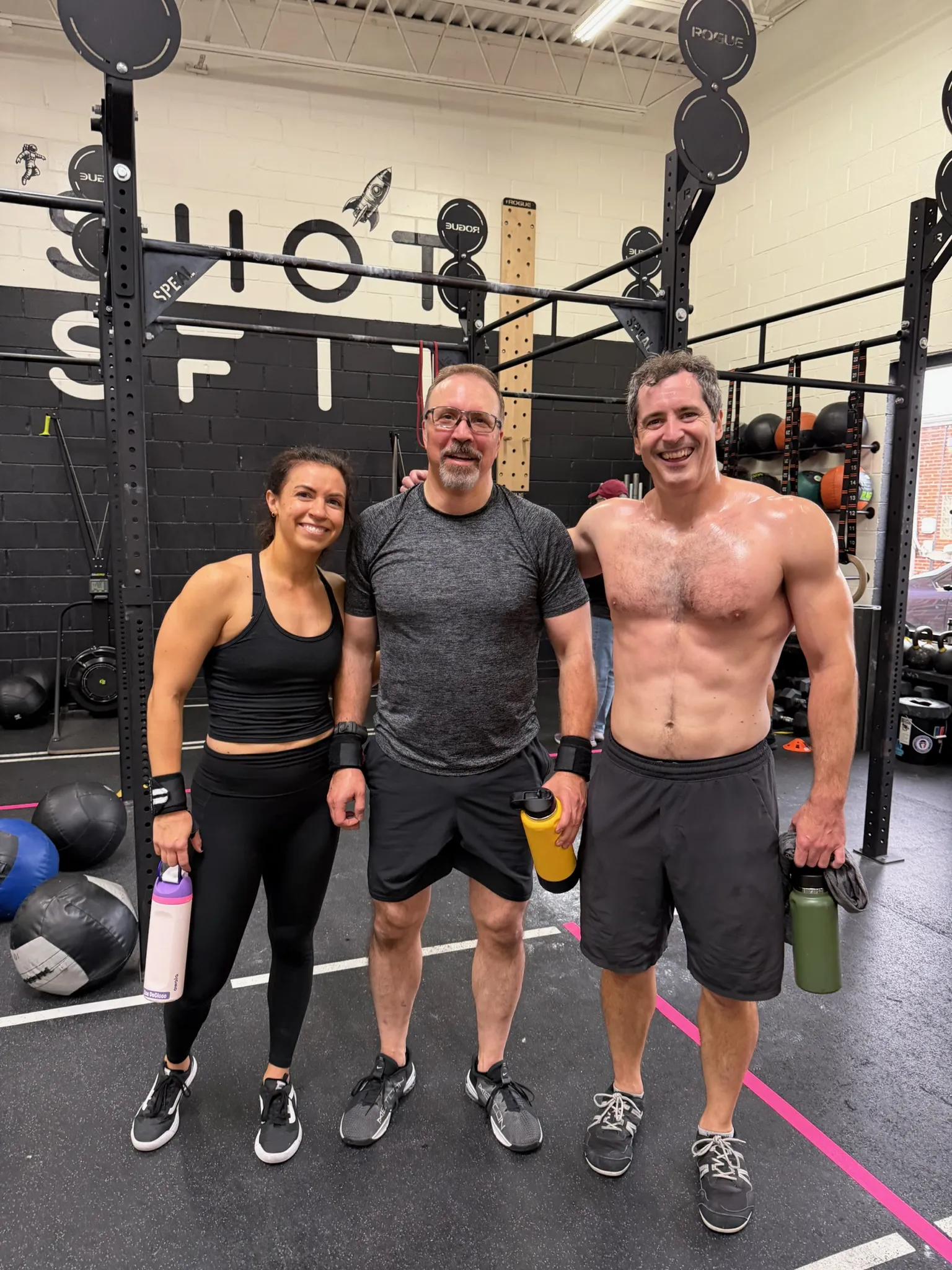 Three Moonshot CrossFit members smiling after a workout at the gym