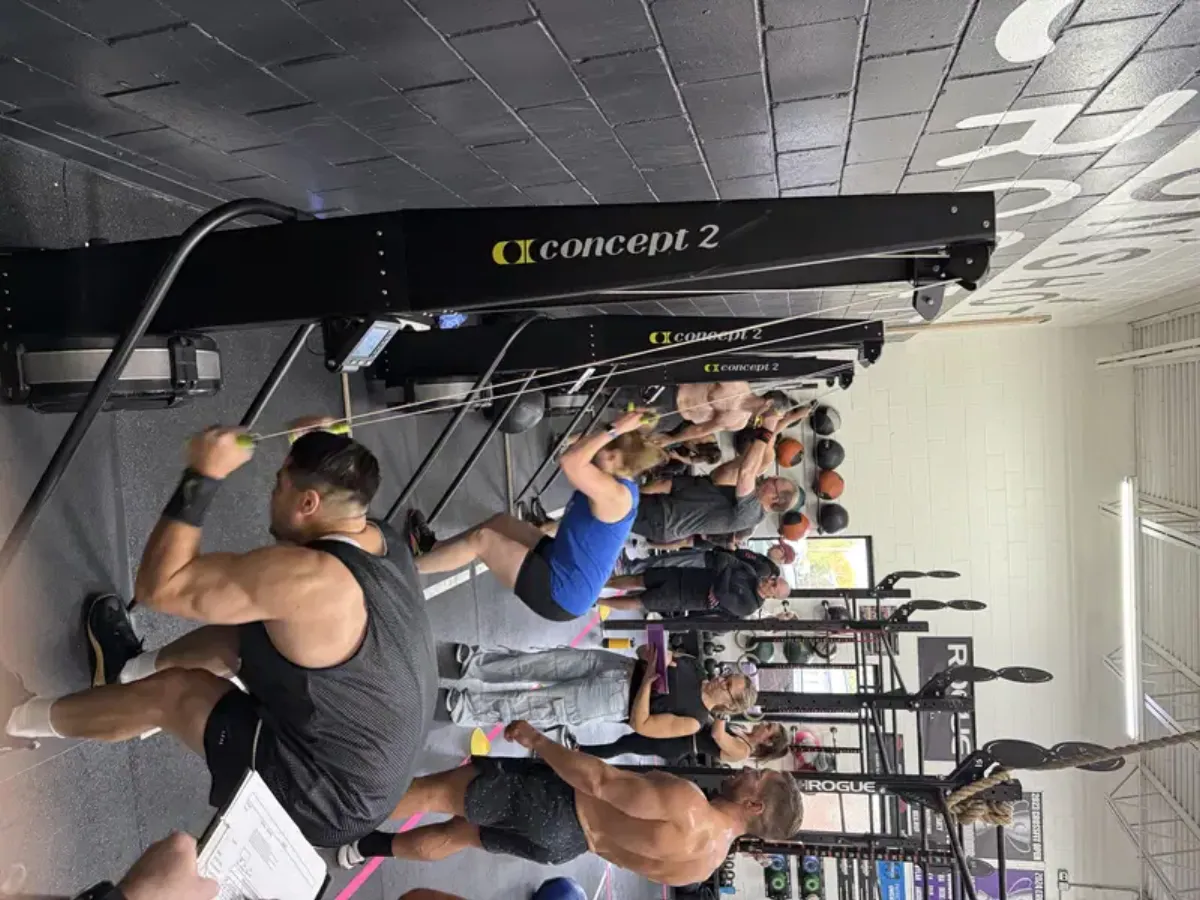 Athletes competing on Concept 2 ski ergs during a Moonshot CrossFit event with coaches judging