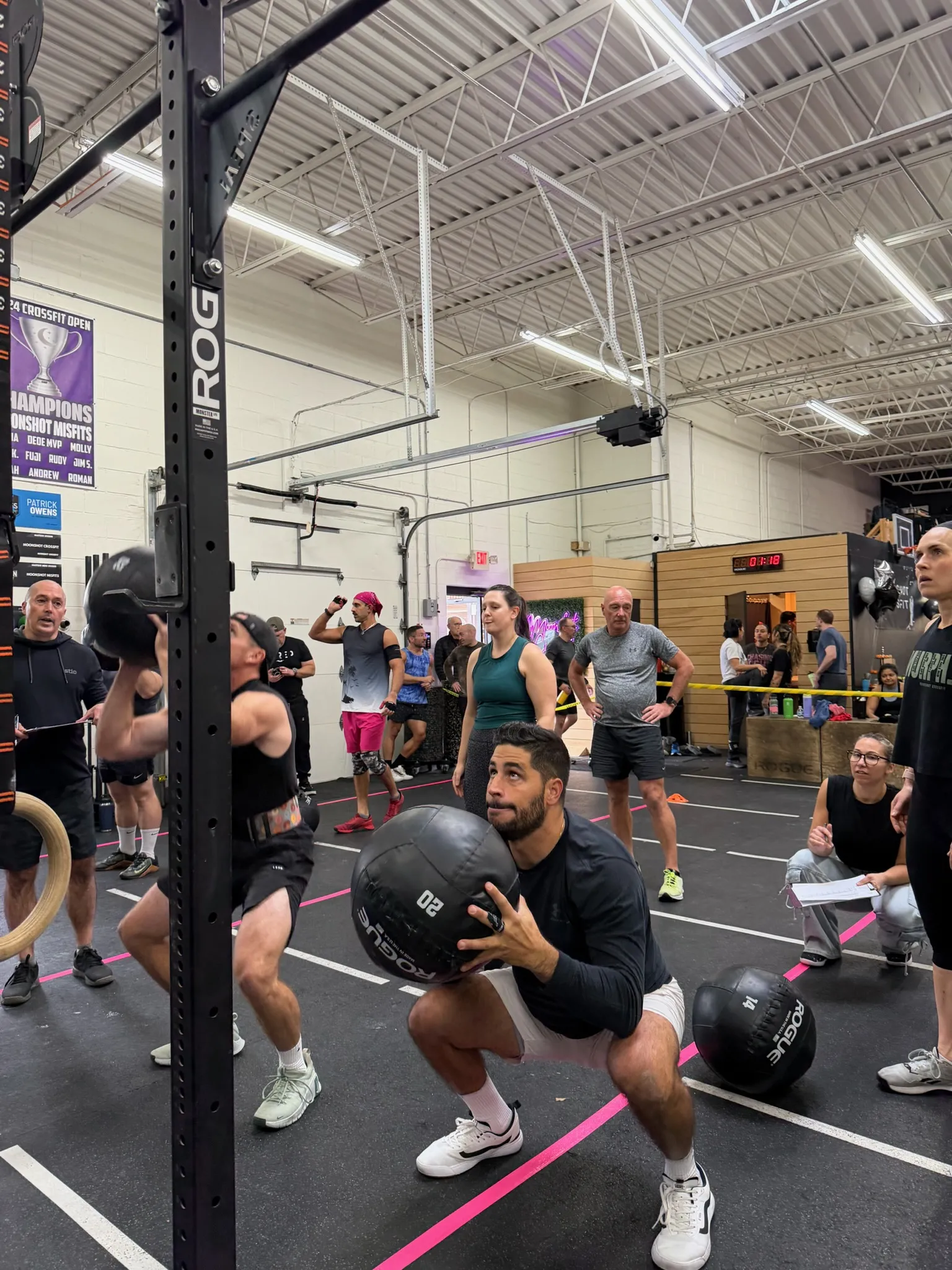 Member performing a wall ball squat during a competition workout at Moonshot CrossFit