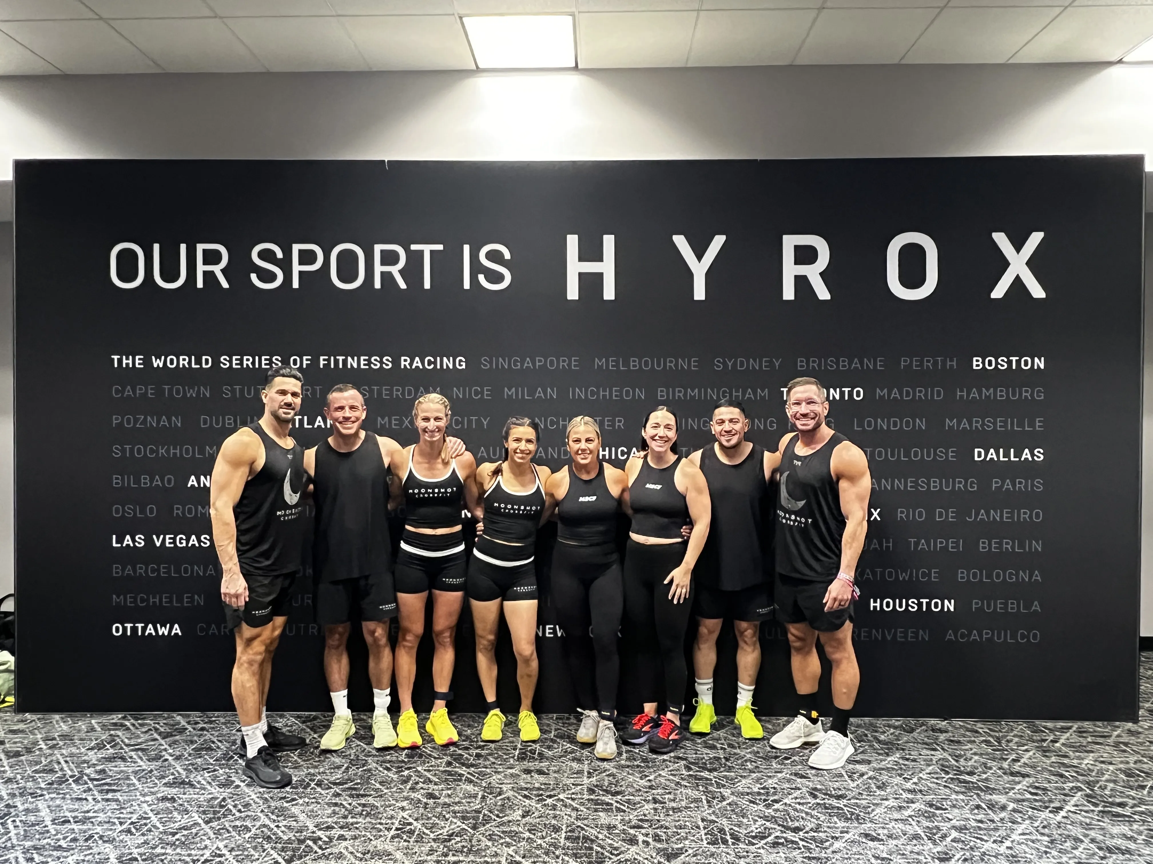 Moonshot CrossFit team in front of the Hyrox wall at a race
